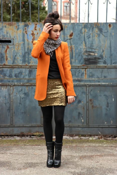 garota com saia de lantejoulas e casaco laranja 