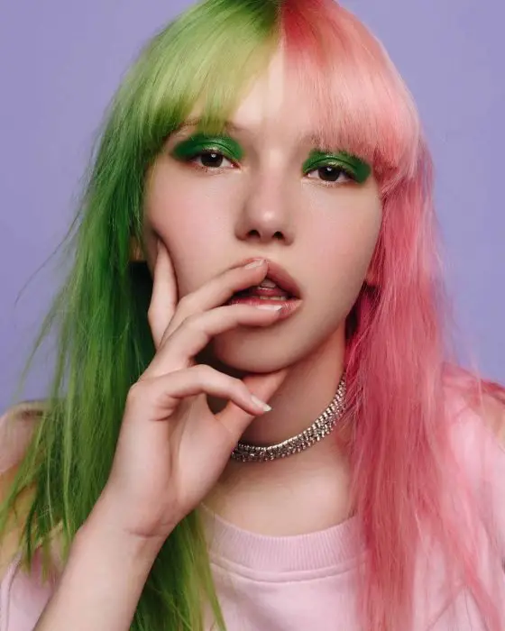 Menina com cabelos de cores diferentes, verde e rosa
