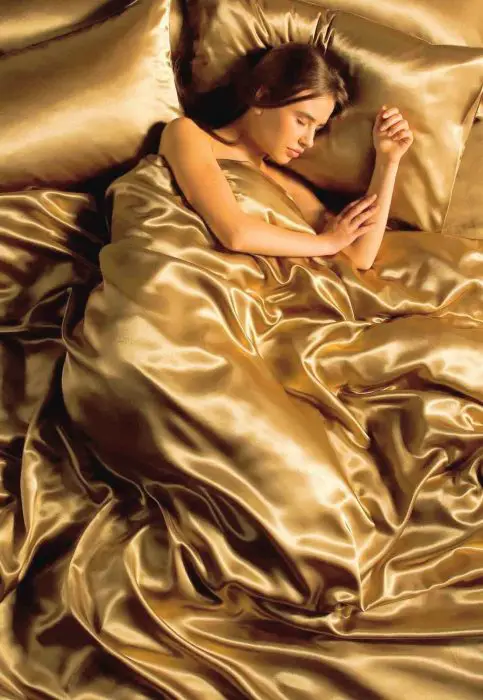 Menina dormindo em lençóis de seda 
