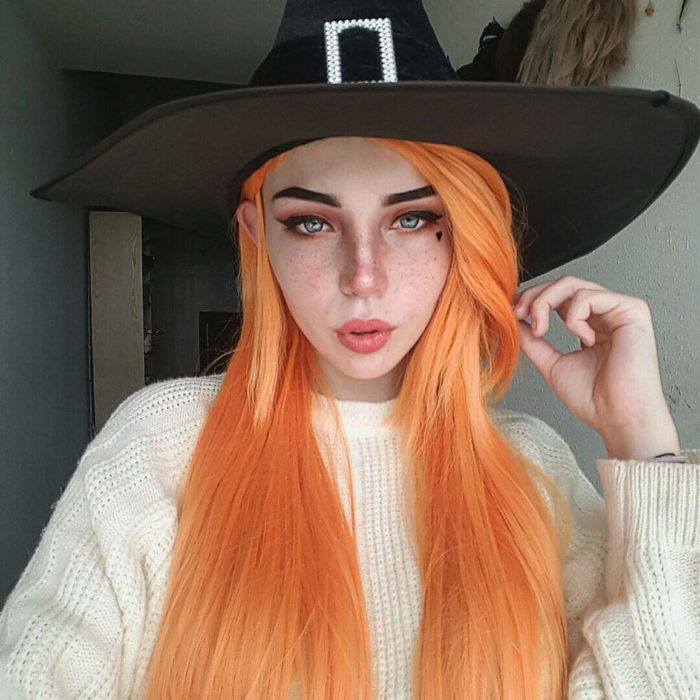 Menina com maquiagem leve fingindo ser uma bruxa