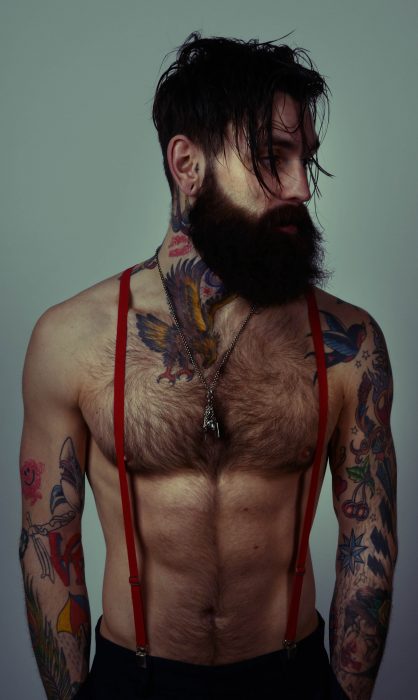 Cara hipster com barba e tatuagens 