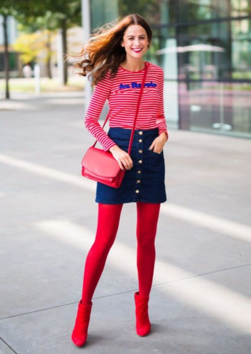 Trajes com meia-calça colorida;  garota com blusa listrada, saia jeans abotoada, meia-calça vermelha e botins