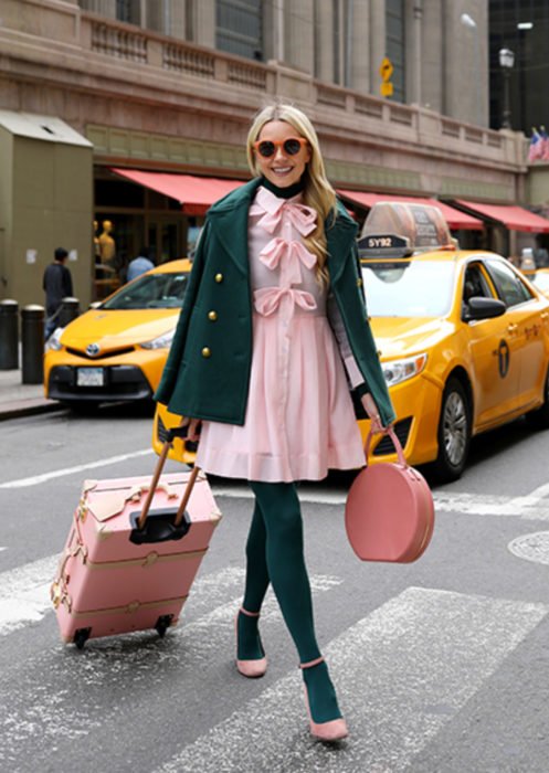 Trajes com meia-calça colorida;  mulher com mala atravessando a rua com táxis atrás, cabelo loiro, óculos de sol laranja, vestido e sapatos rosa, jaqueta e meias verdes