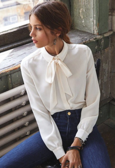Conjunto com blusa branca;  mulher olhando pela janela com camisa de marfim e laço no pescoço