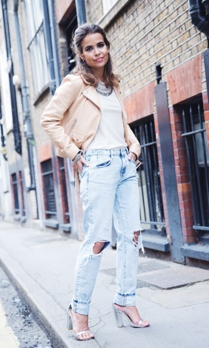 mulher com jeans rasgado e jaqueta pêssego 