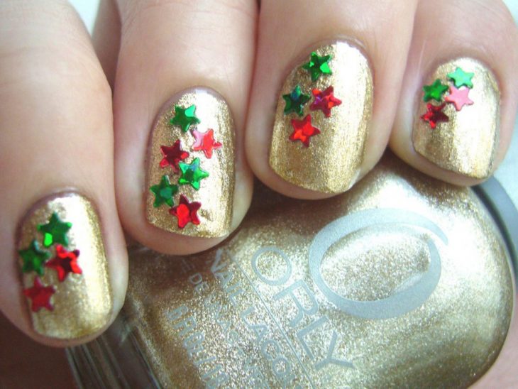 Desenho de unhas de Natal, unhas decoradas com esmalte dourado e estrelas 