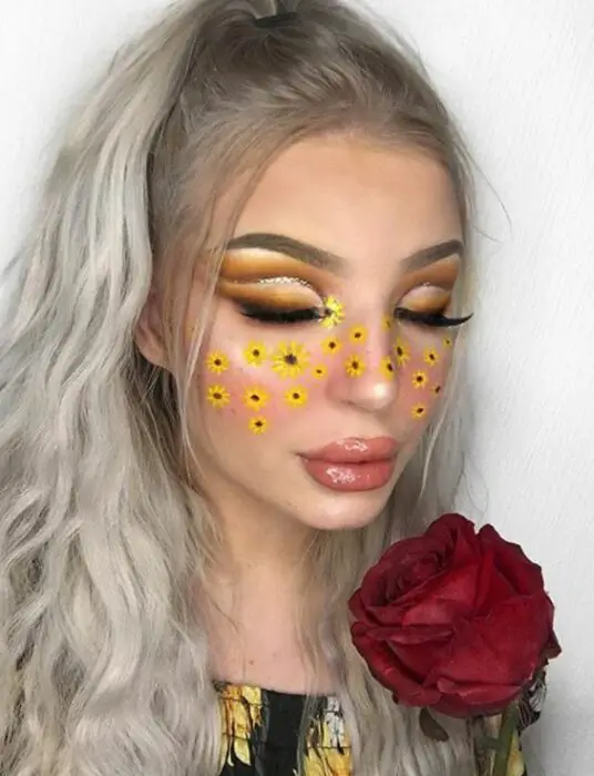 Maquiagem estética em tons de amarelo, com girassóis no rosto