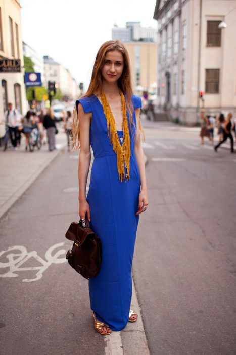 Rapariga com um vestido longo azul e um colar amarelo