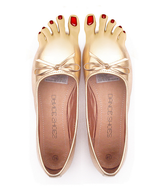 sapatos de ponta dourada têm dedos com unhas vermelhas 