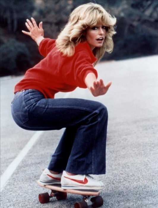 Moda feminina dos anos 70;  Farrah Fawcett no skate com suéter vermelho;  penteado retrô