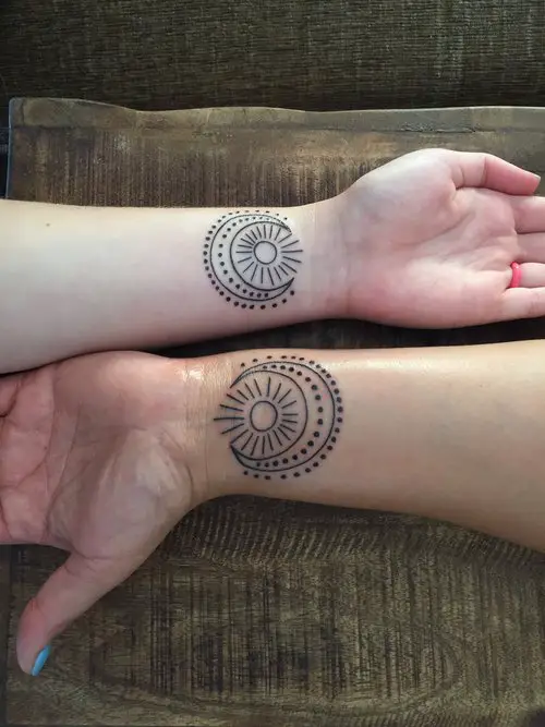 Tatuagens de sol, lua e estrelas nos pulsos 