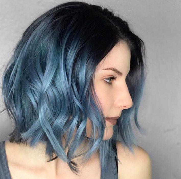 Menina usando um corte de cabelo longo em camadas bob com um tom azul 