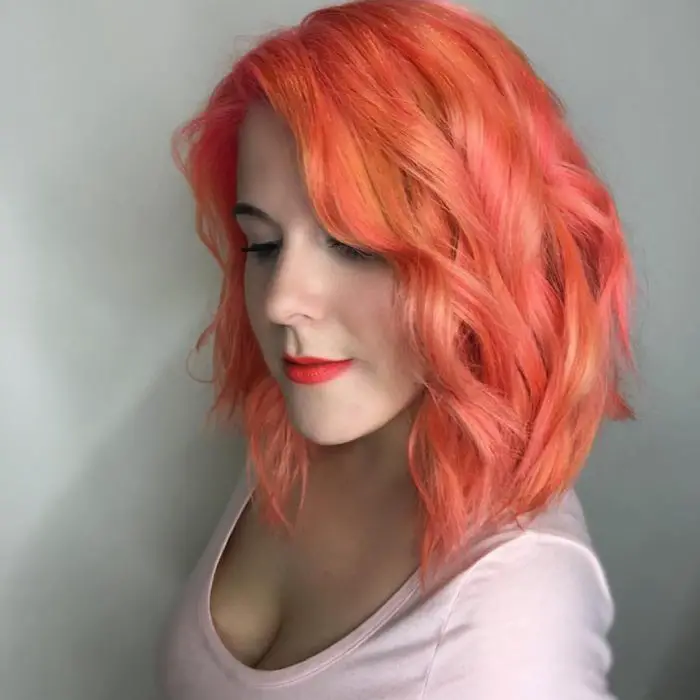 Rapariga com um corte de cabelo longo bob com uma tonalidade laranja 