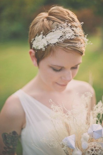 penteados para o dia do seu casamento.  garota usando uma faixa de flor branca no cabelo curto 