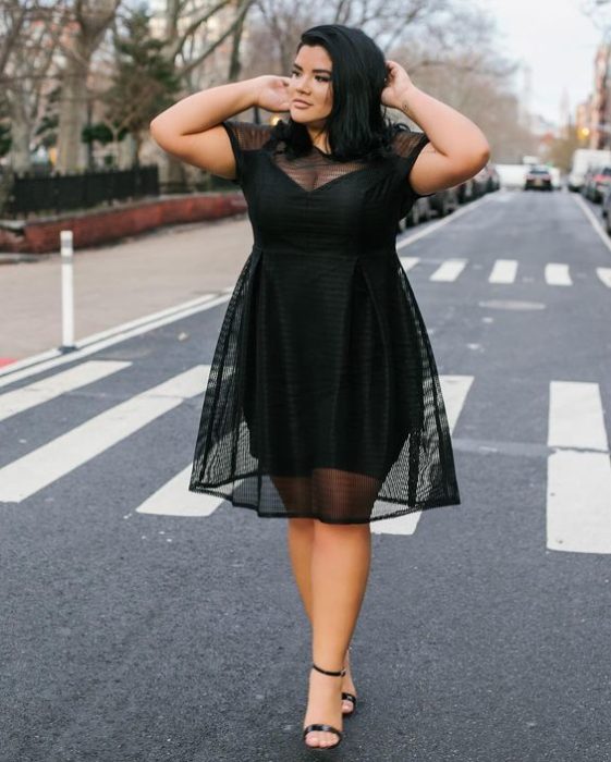 Garota Currvy usando um vestido preto transparente 