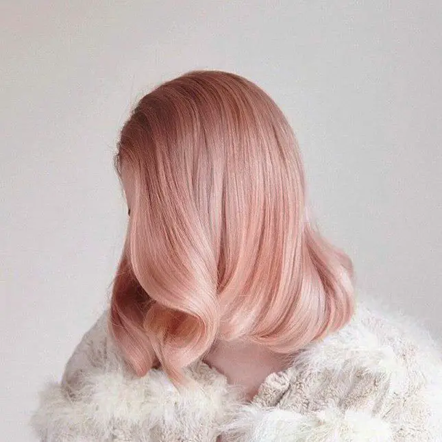 Menina com estilo dos anos 40 e cabelo rosa-dourado 