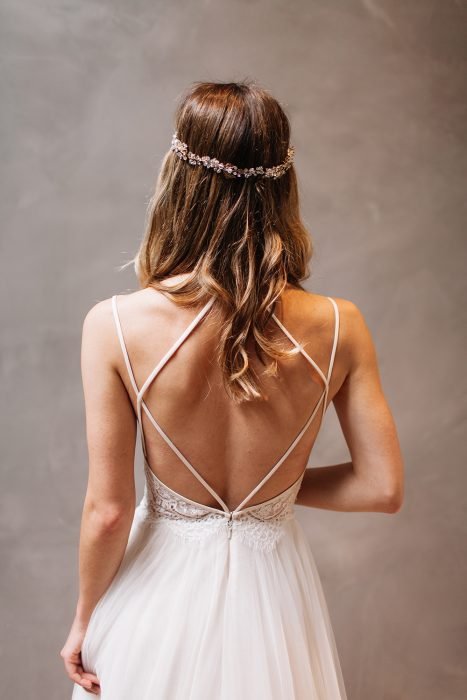 Rapariga com um vestido de noiva com decote nas costas a posar para uma sessão de fotos 