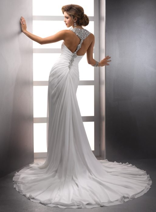 Rapariga com um vestido de noiva com decote nas costas a posar para uma sessão de fotos 