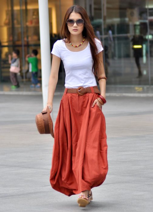Saias para o verão;  menina andando na rua com saia longa vermelha e com bolsos