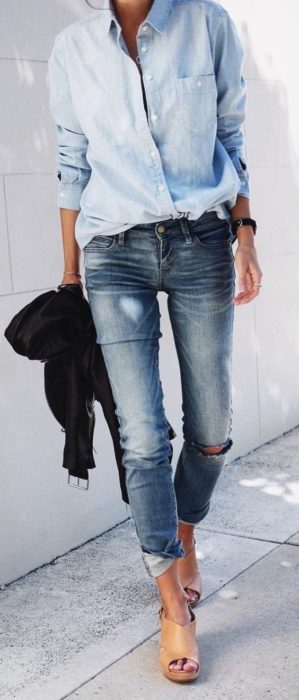Menina vestindo uma blusa jeans com jeans rasgado 
