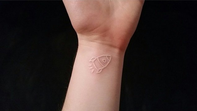Tatuagem de foguete feita com tinta branca 