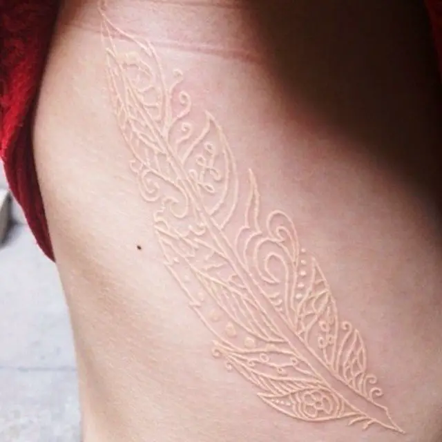 Tatuagem de pena feita com tinta branca 