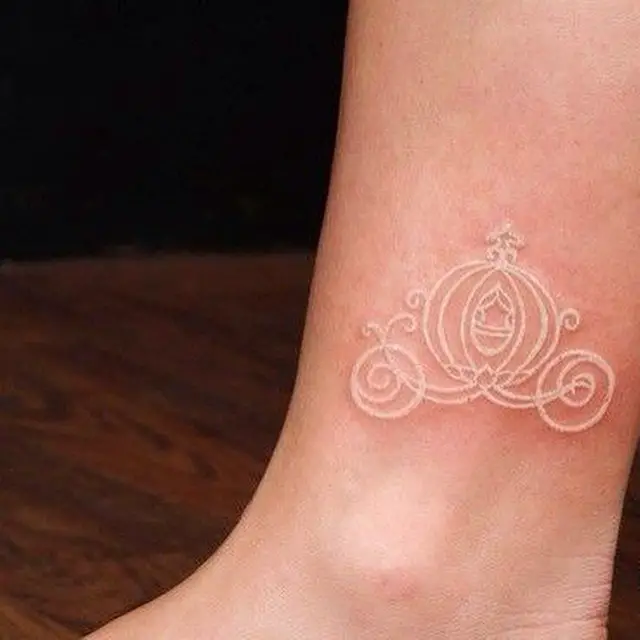 Tatuagem de carruagem de Cinderela feita com tinta branca 