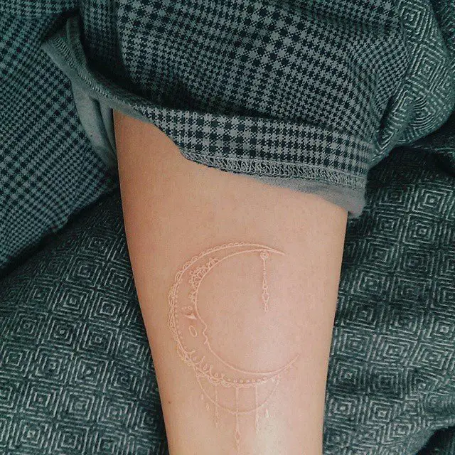 tatuagem da lua feita com tinta branca 