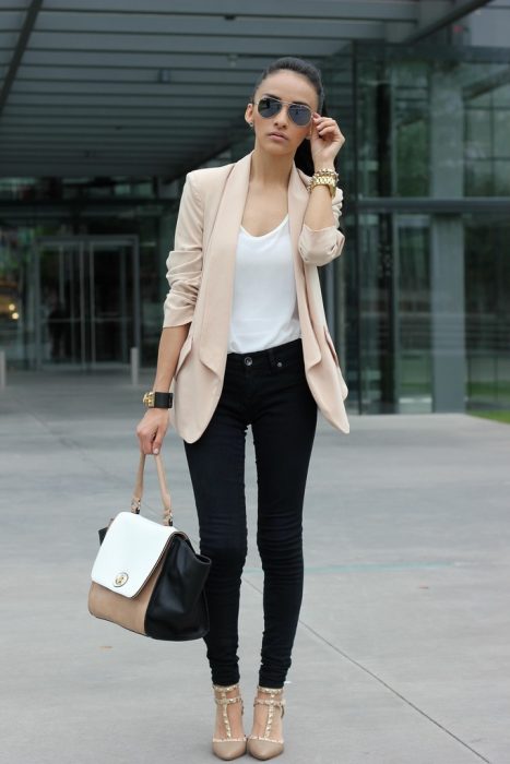 Garota vestindo jeans preto com um blazer marrom e blusa branca 