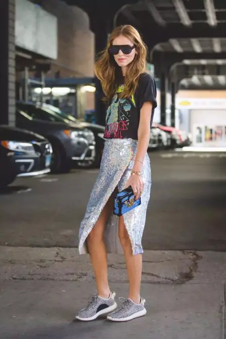 Menina usando saia de lantejoulas com camiseta de desenho animado e tênis adidas Yzzy