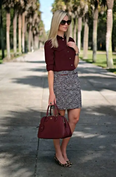 Roupas de escritório.  Menina vestindo uma saia cinza e uma blusa cor cereja 