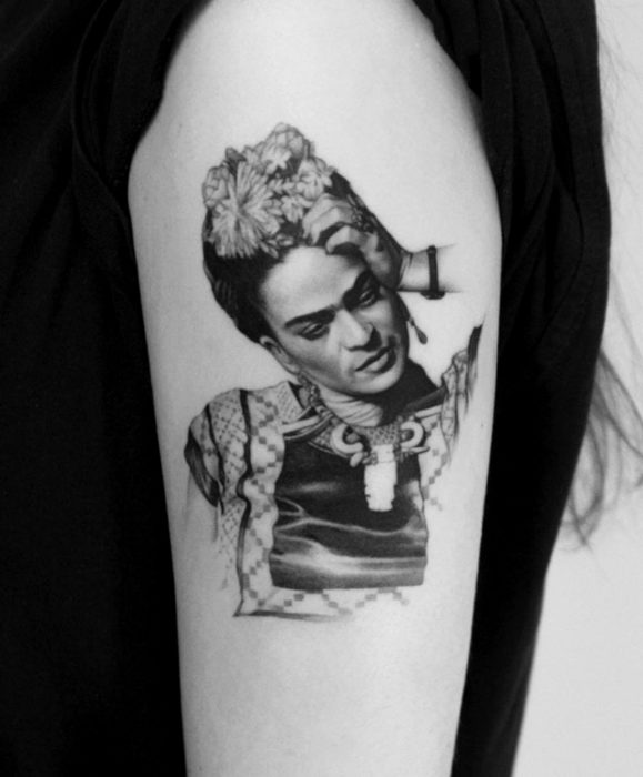 Tatuagens realistas de Frida Kahlo no braço, preto e branco, em tons de cinza