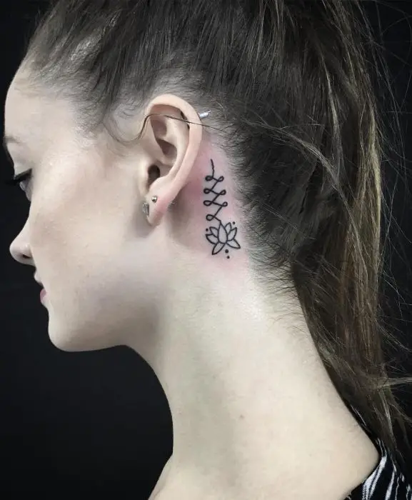 Menina com uma tatuagem em forma de flor atrás da orelha