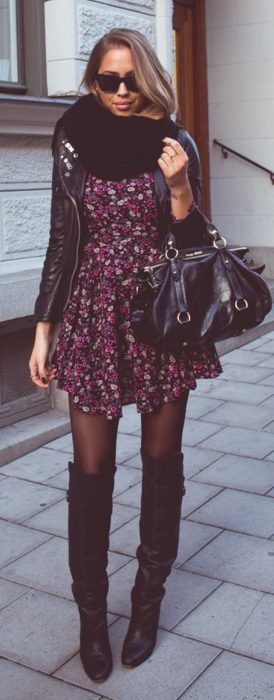 Menina usando um vestido com botas com estampa floral e jaqueta preta 