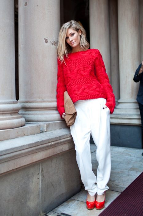 Menina vestindo calça branca, suéter vermelho e sapatos vermelhos 