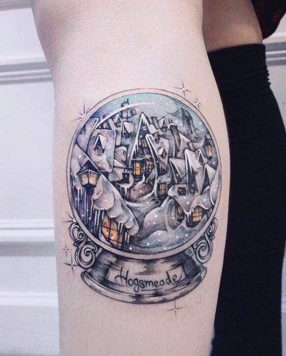 Menina com tatuagem de bola de cristal inspirada em Harry Potter;  Tatuagens em miniatura para quem ama o Natal