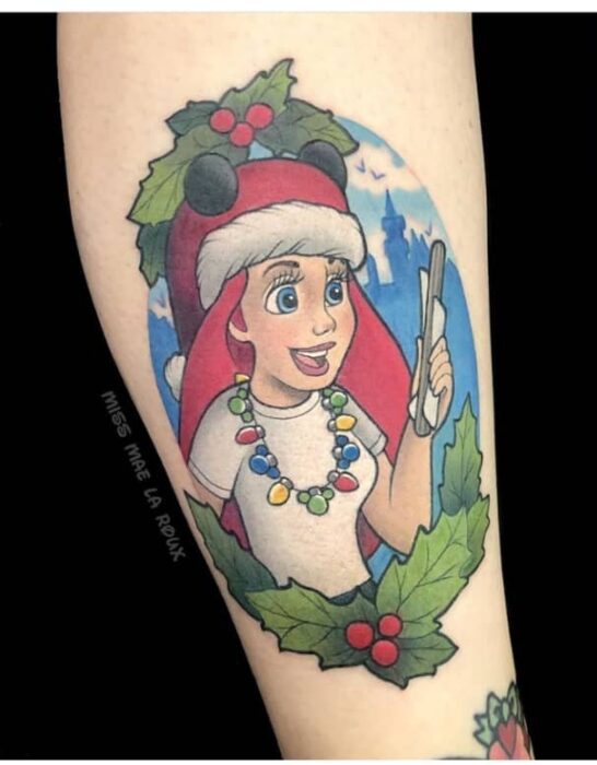 Menina com tatuagem de Ariel comemorando o Natal;  Tatuagens para meninas que amam o Natal