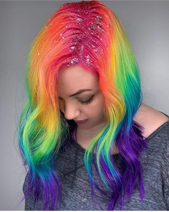 Menina com cabelo longo, ondulado e colorido do arco-íris, rosa, laranja, amarelo, verde, azul e roxo com diamante na raiz