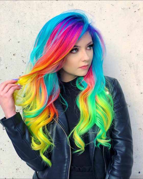 Menina com cabelos longos e ondulados e cores neon do arco-íris, rosa, roxo, azul, laranja, vermelho, amarelo e verde