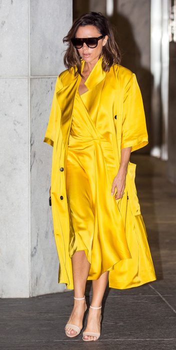 Victoria Beckham usando um vestido amarelo e um sobretudo amarelo 