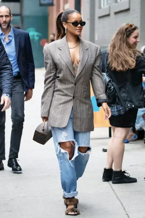 Rihanna andando pela rua vestindo um blazer look com jeans 