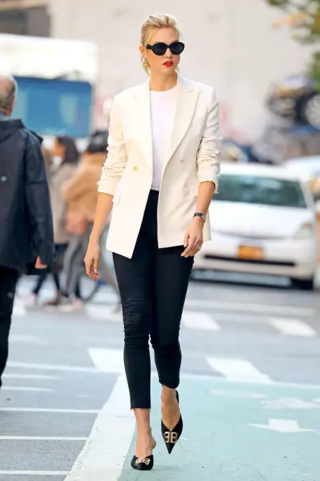 Garota vestindo um blazer branco com jeans preto 