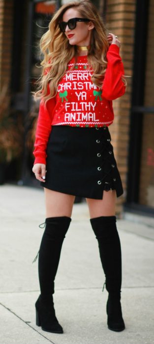 Menina vestindo um suéter de Natal feio com botas longas e saia preta 