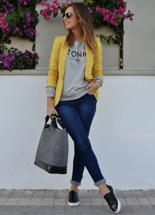 Menina vestindo um blazer amarelo, blusa amarela e jeans 
