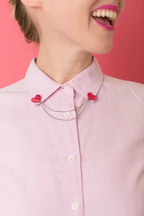 Dicas de colarinho;  clipes para colarinho de camisa;  corações vermelhos com corrente de ouro em blusa rosa pastel