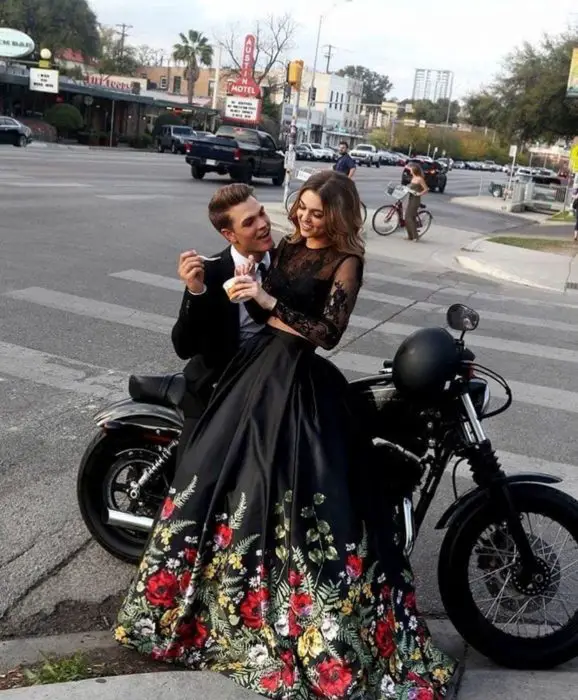 Casal usando roupas elegantes sentado em uma motocicleta na rua