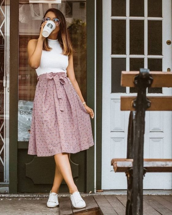 Menina tomando café na entrada da casa dela 