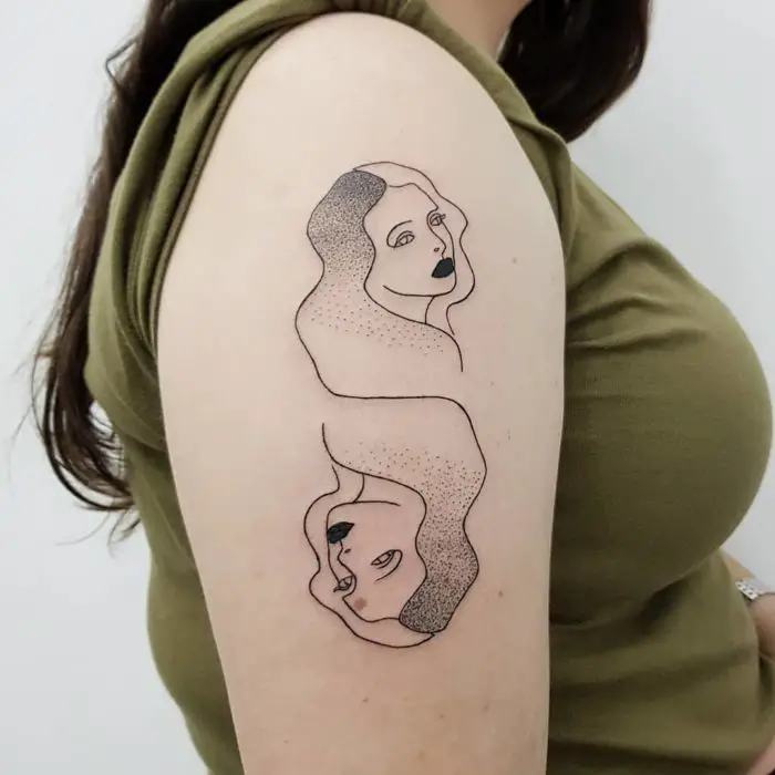 Tatuagem de Gêmeos em tinta preta na parte externa do braço