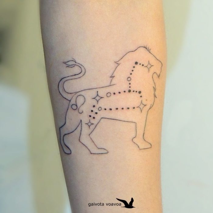 Tatuagem da constelação de Leão com a silhueta de um leão ao redor na área do antebraço