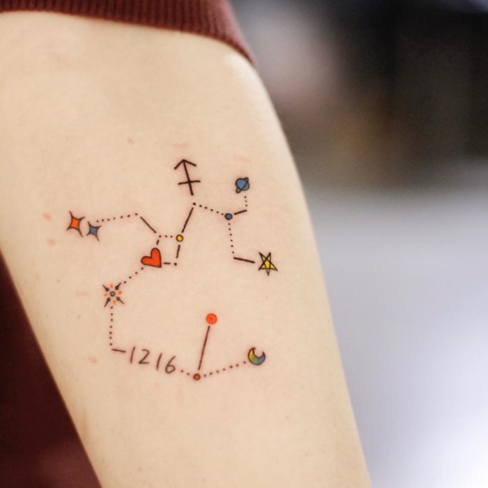 Tatuagem colorida de constelação de sagitário na área do antebraço